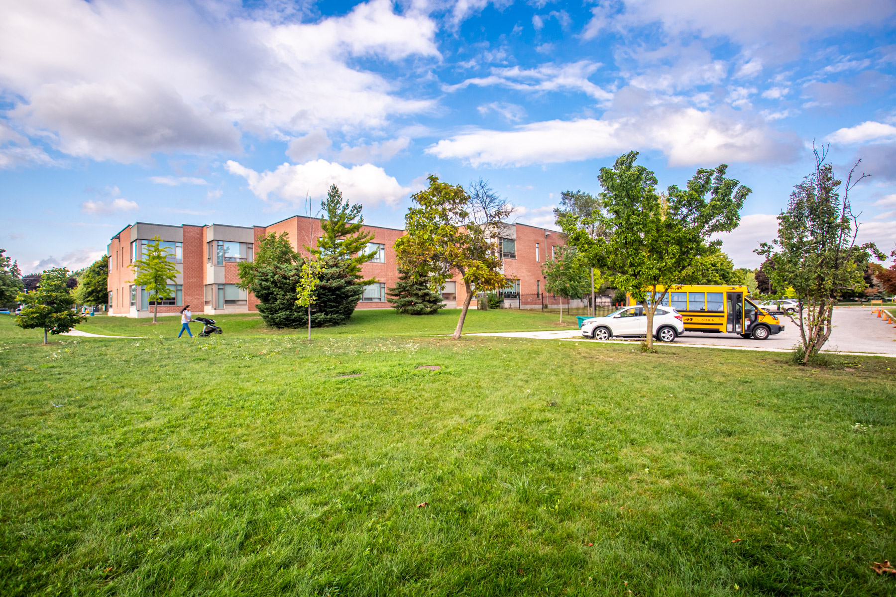 Photo of Glen Park Public School lawn, red-brick building and yellow school bus.
