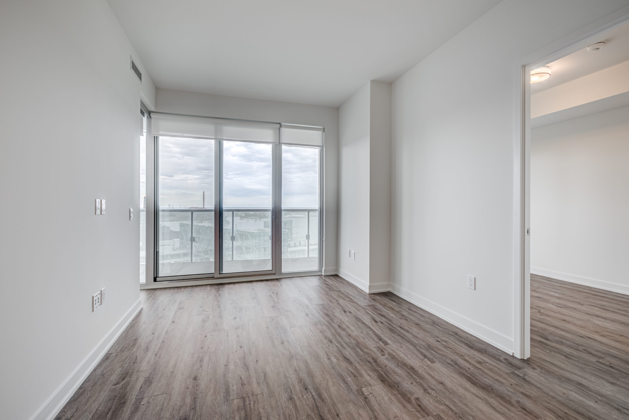 Brightly lit condo living room and walkout balcony.