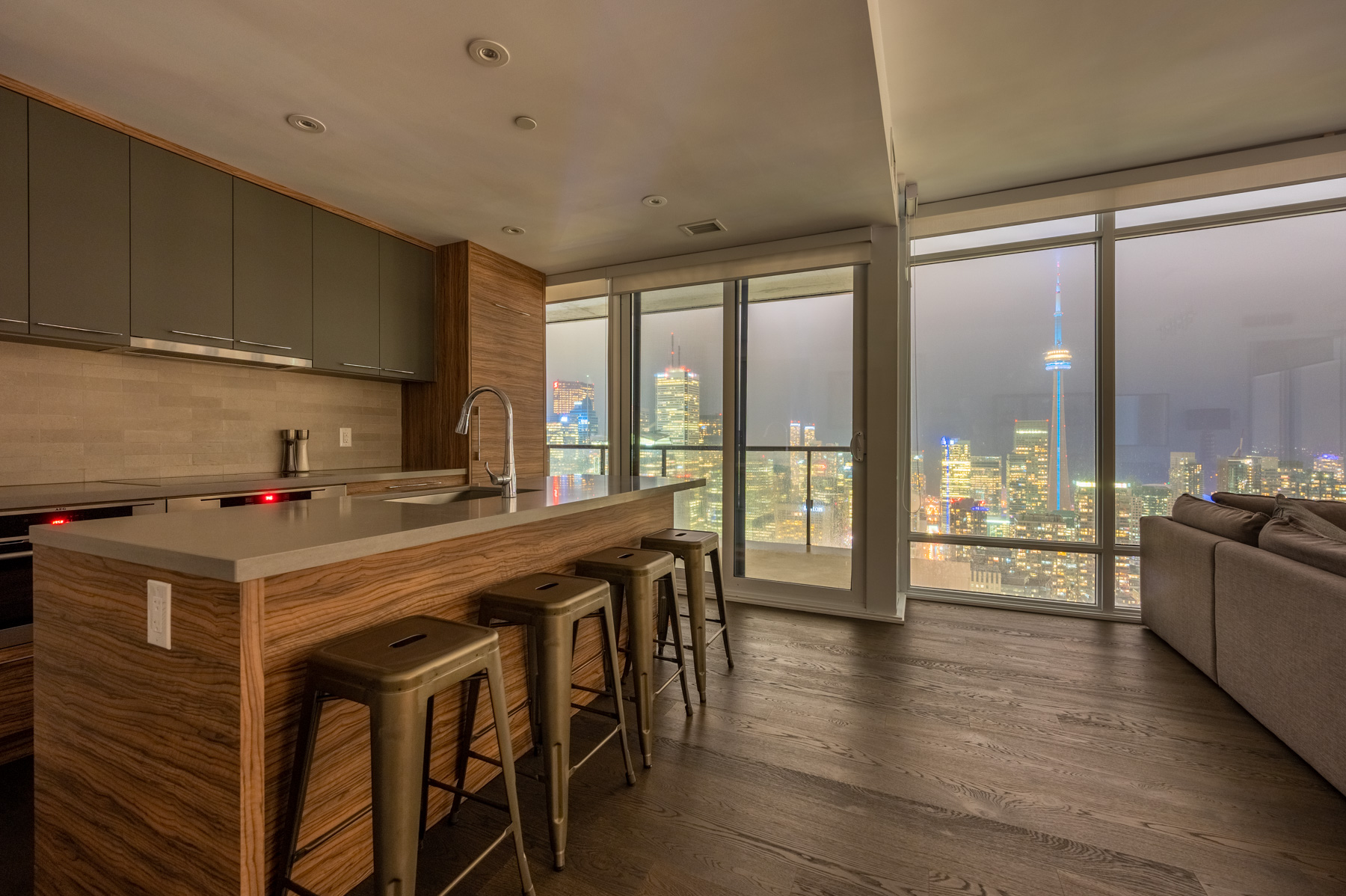 Condo dining room with view of Toronto at night.