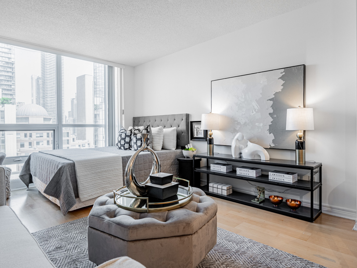 Condo living area lit by floor-to-ceiling windows.