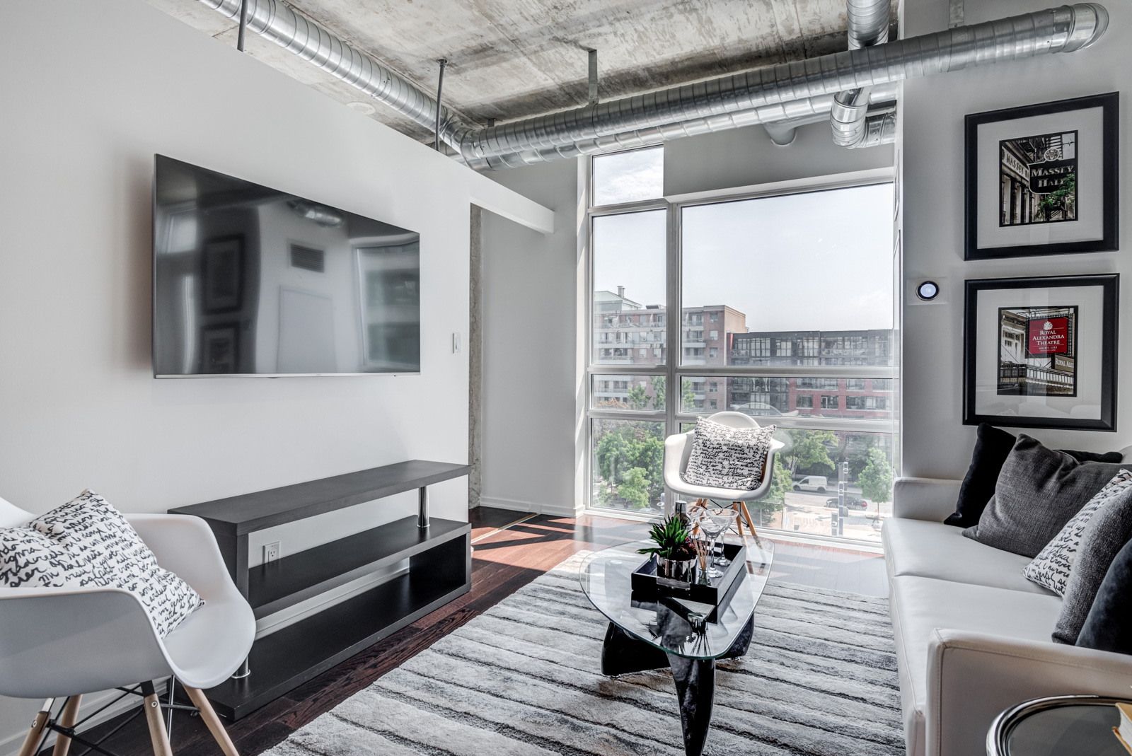 Industrial-style loft with chic living room, wall-mounted art and huge windows.