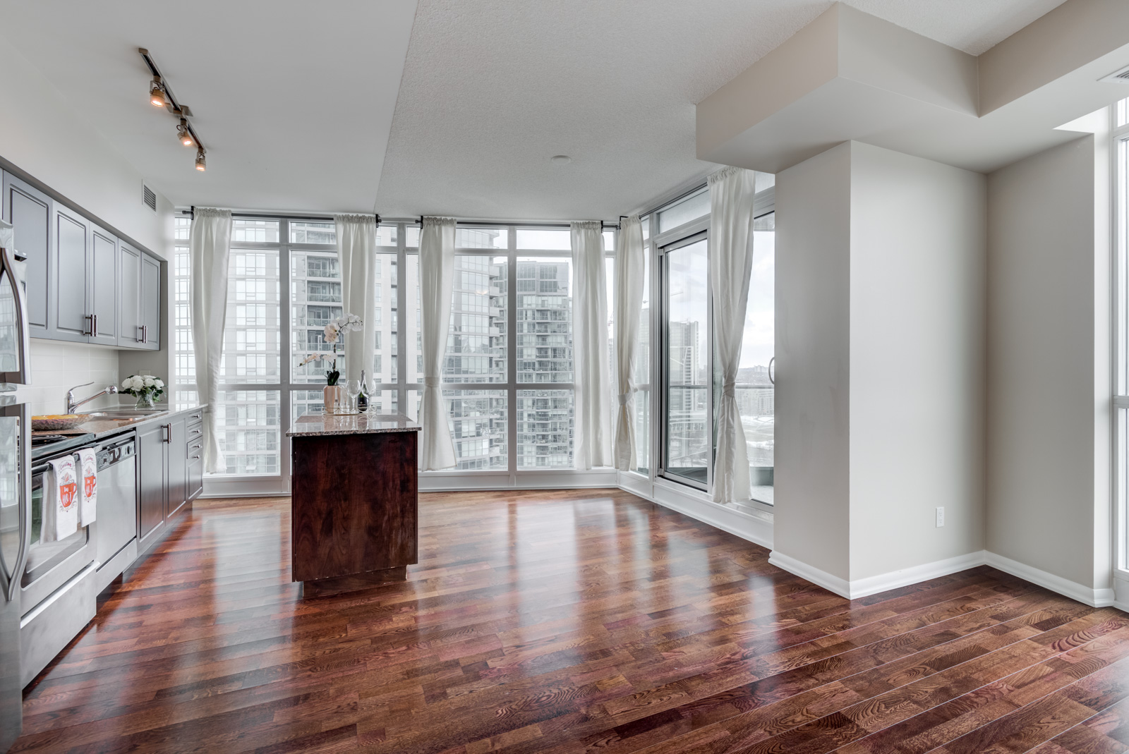 Gray walls and shiny dark brown hardwood floors of 215 Fort York Blvd.