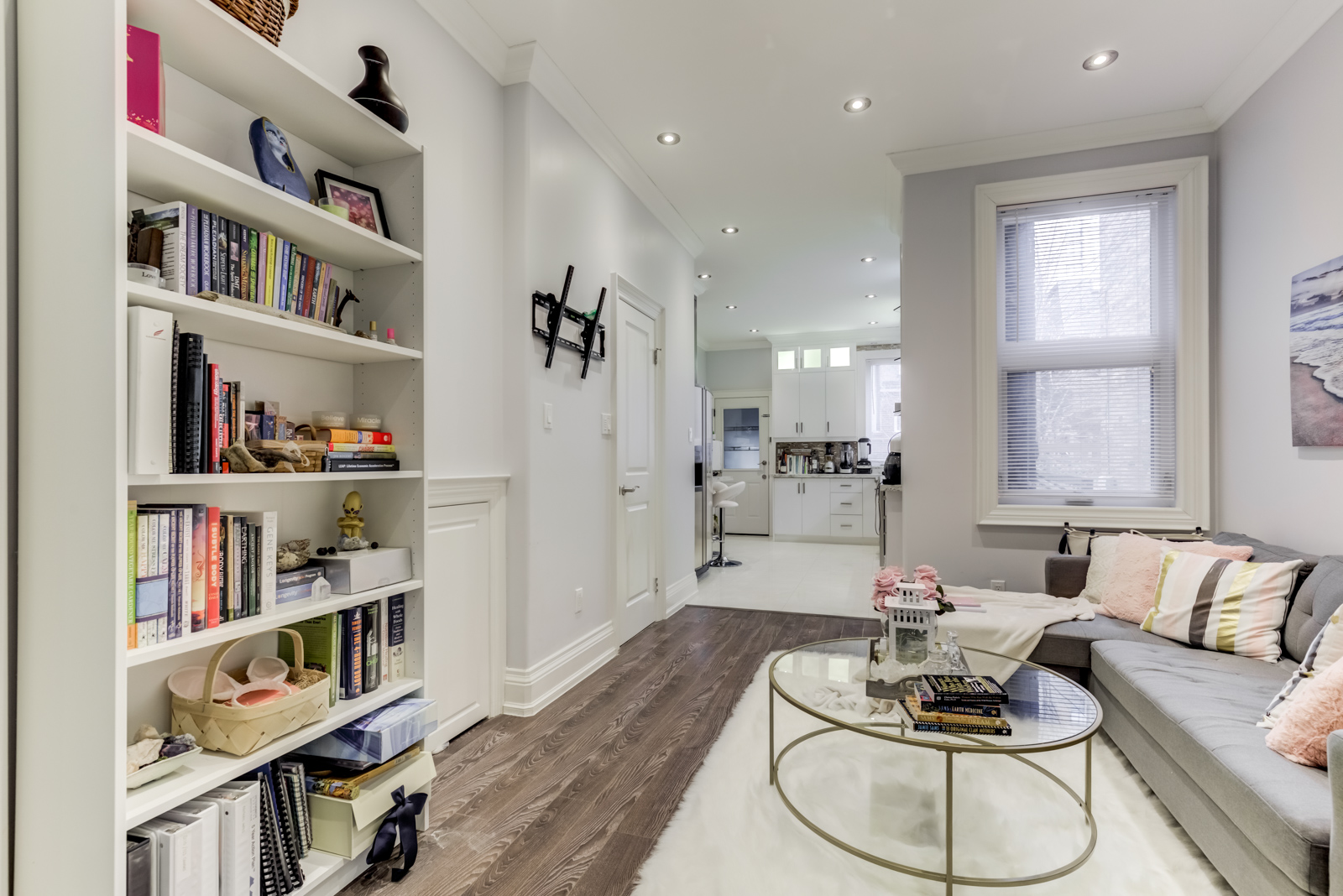 Chic living room with bookshelf, potlights and gray walls.