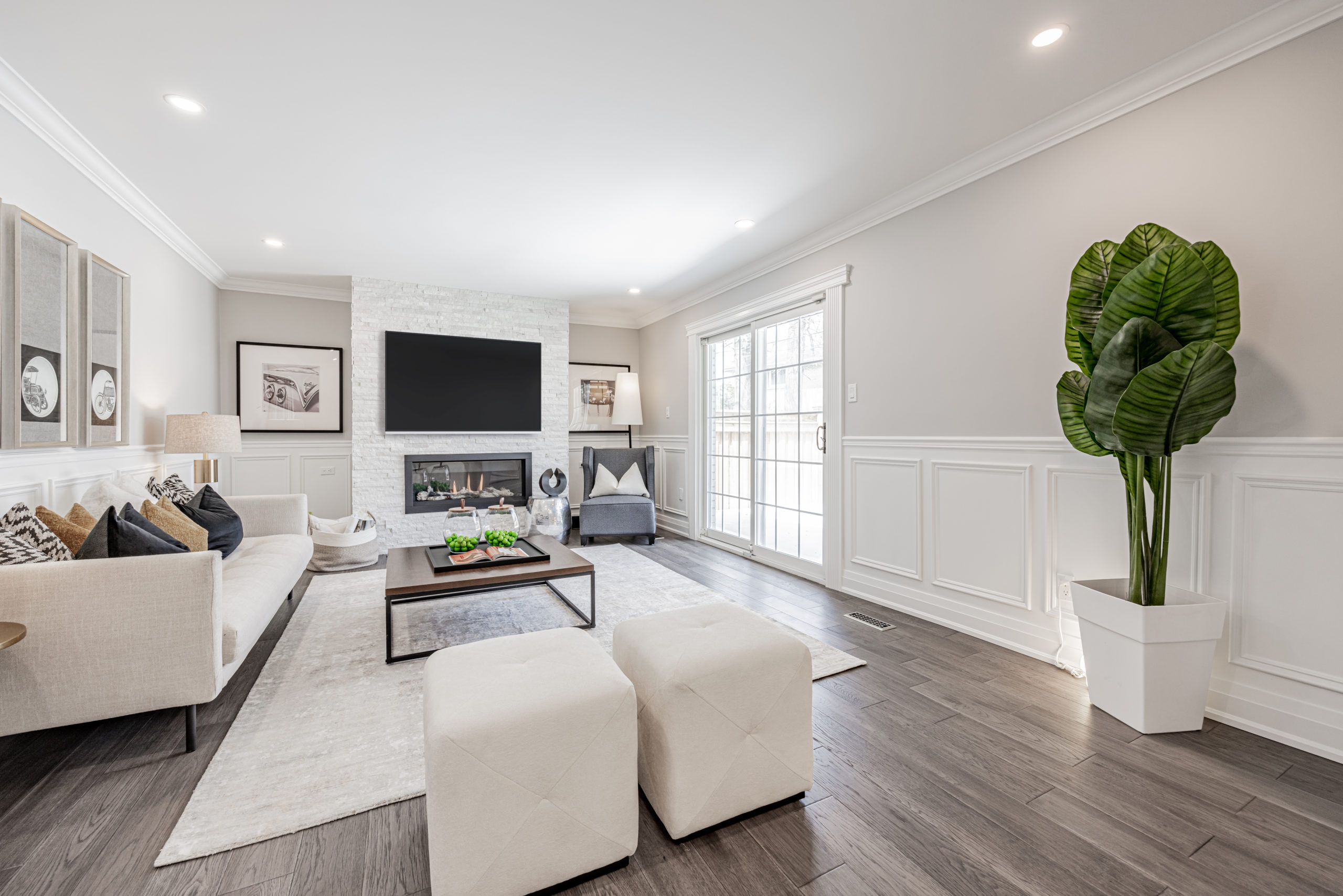 Living room with stone encased gas fireplace and wide-plank hardwood floors.