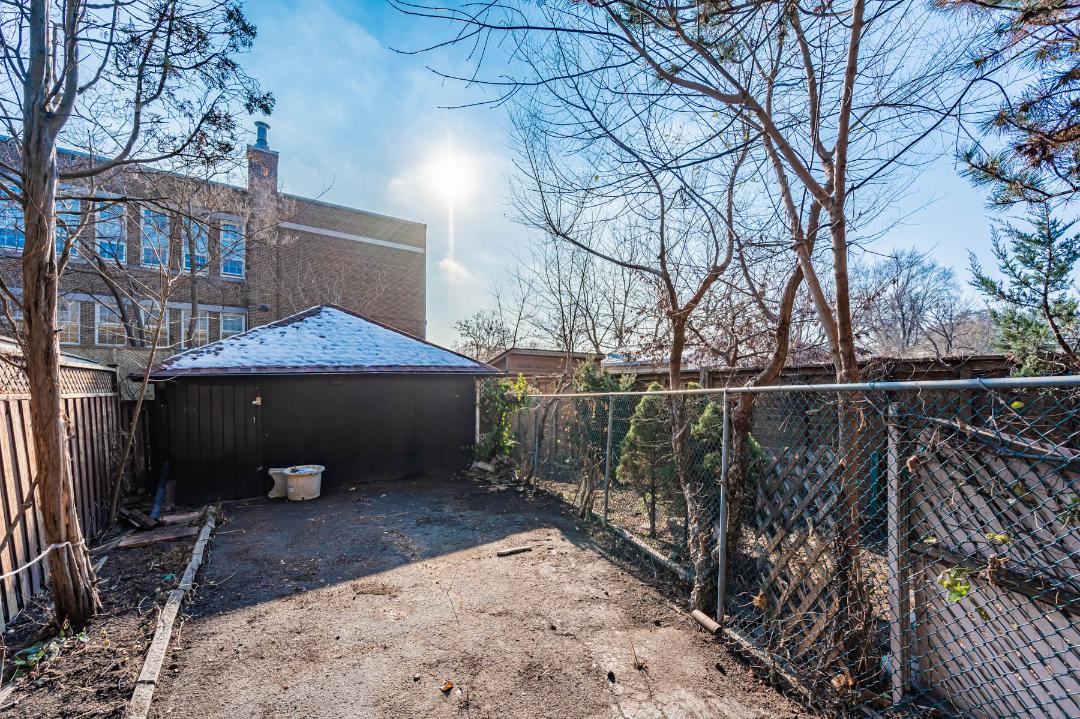 35 Woburn backyard with trees, leaves and black garage.