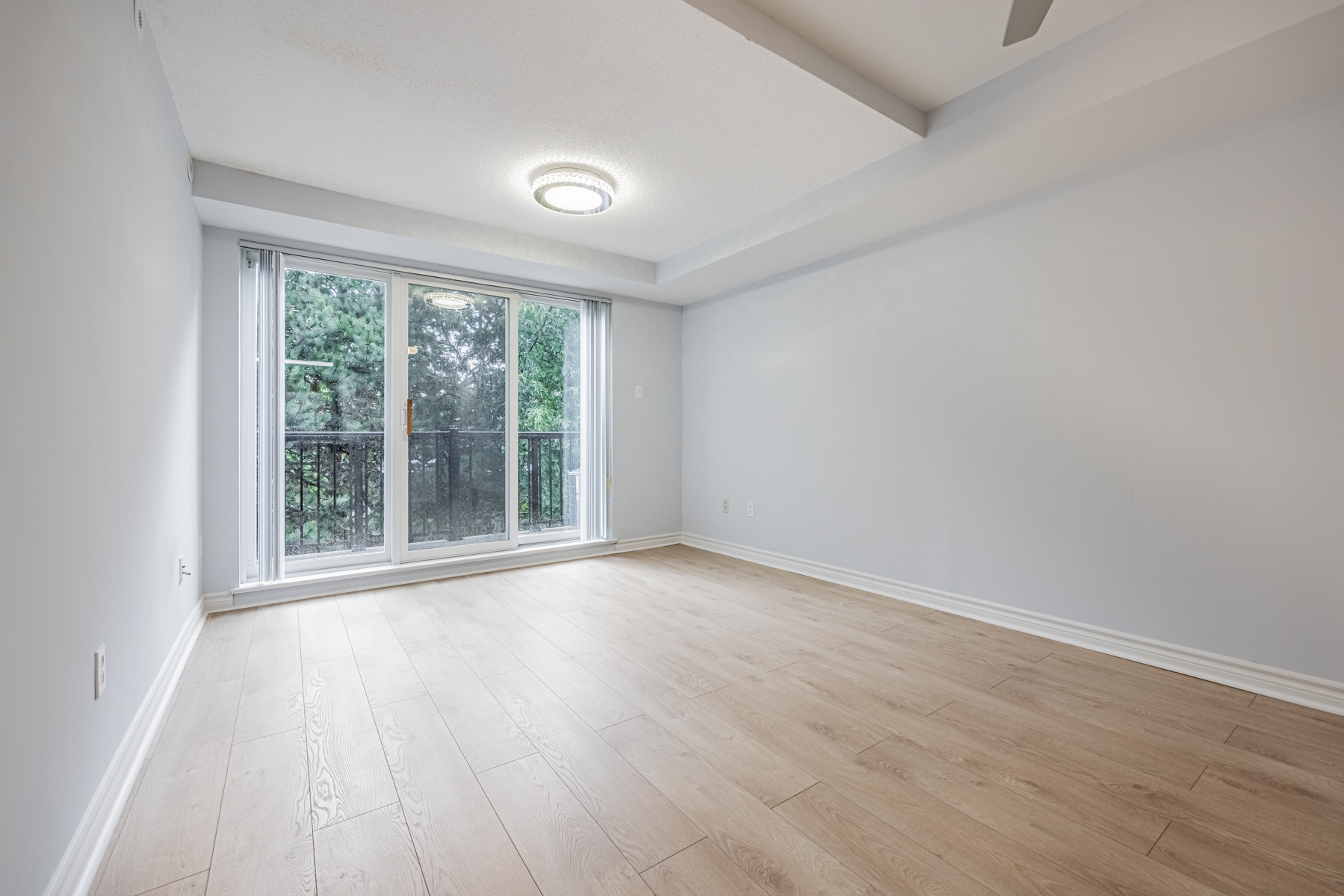 View of trees through balcony windows of 95 George Appleton Way.