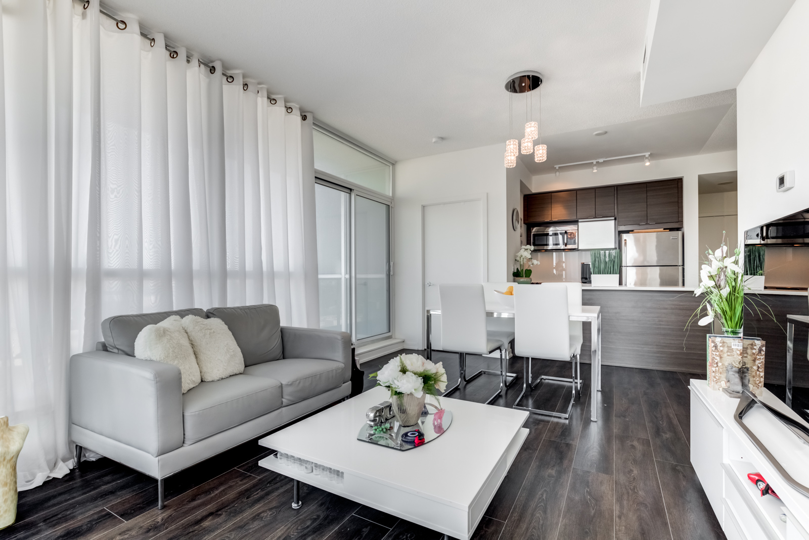 White and gray curtains, walls, furniture and dark floors at 62 Forest Manor Rd Unit 1803, Toronto.