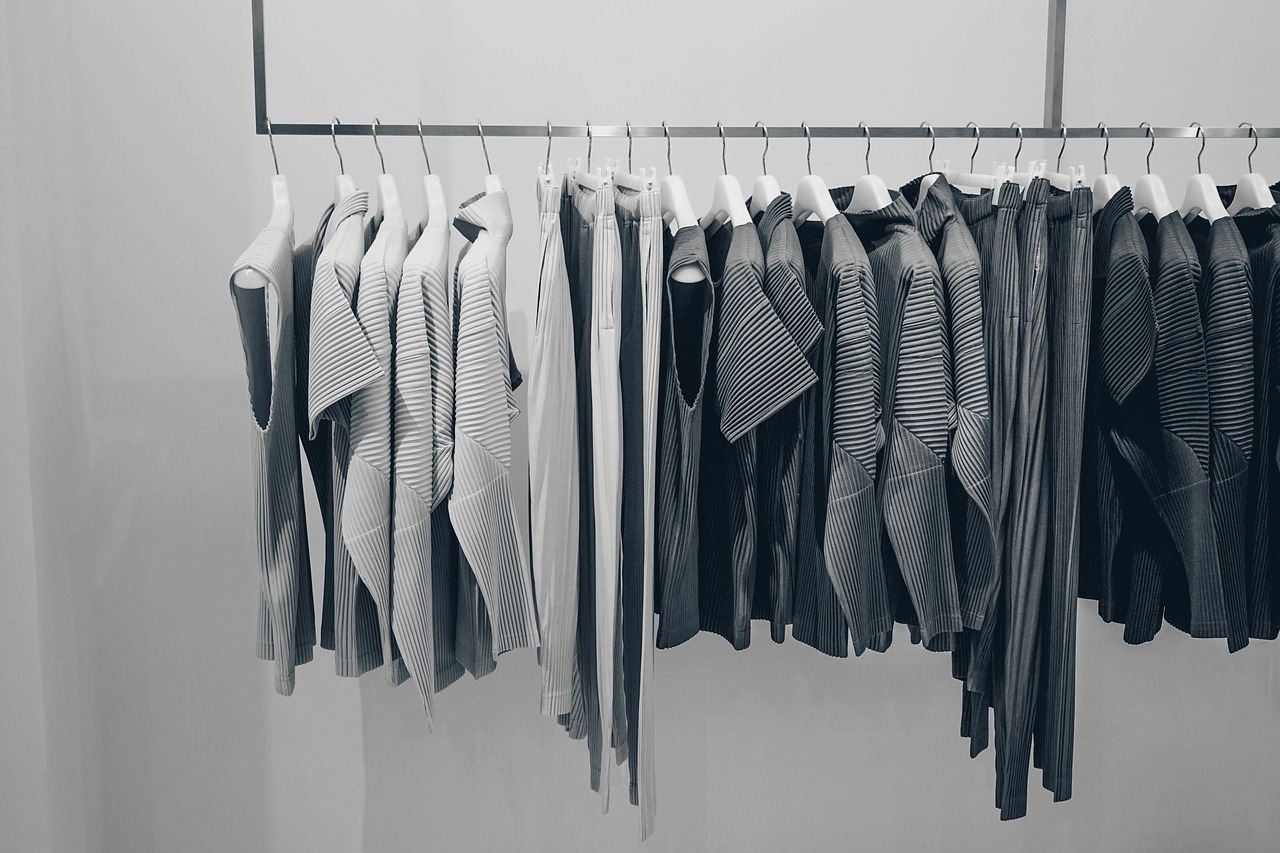 Clothing rack with white, black and gray women's tops in Bathurst neighbourhood clothing store.