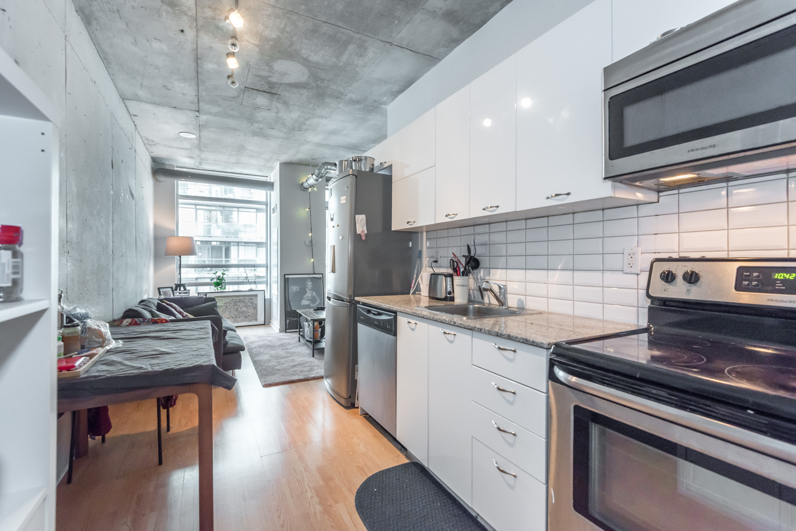 A look at the kitchen from another angle. We can see the counter, cabinets, appliances and lights.