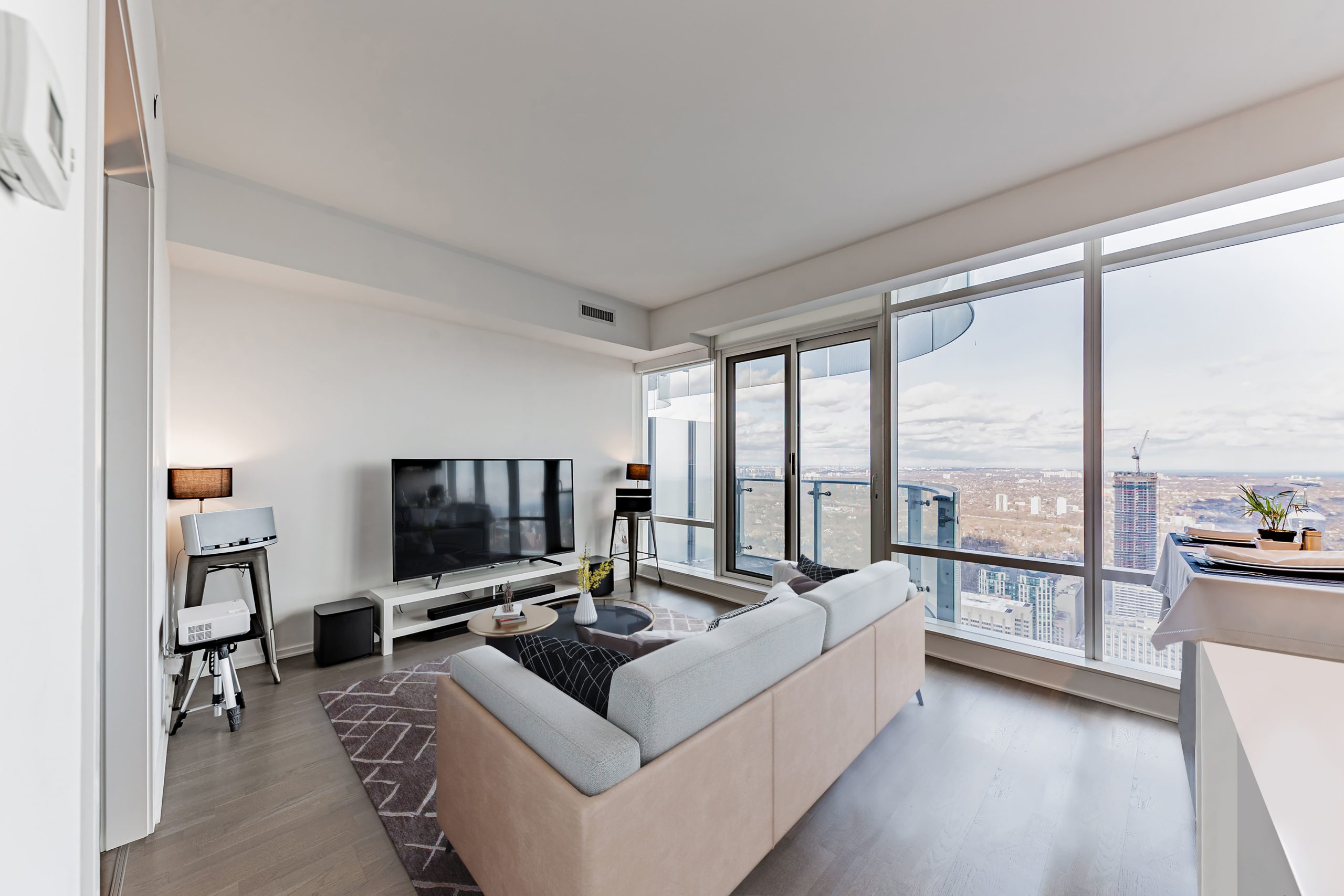 Toronto condo living and dining room with large. Wall-to-wall windows.