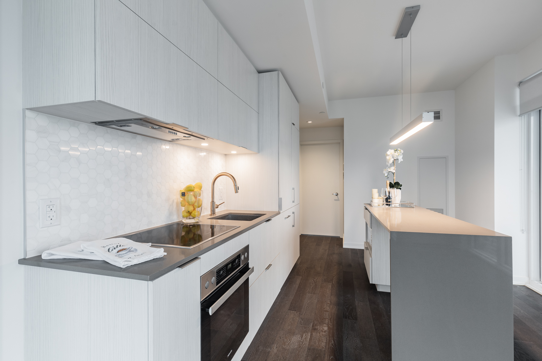 Close up of kitchen back-splash with shiny hexagon-shaped tiles.