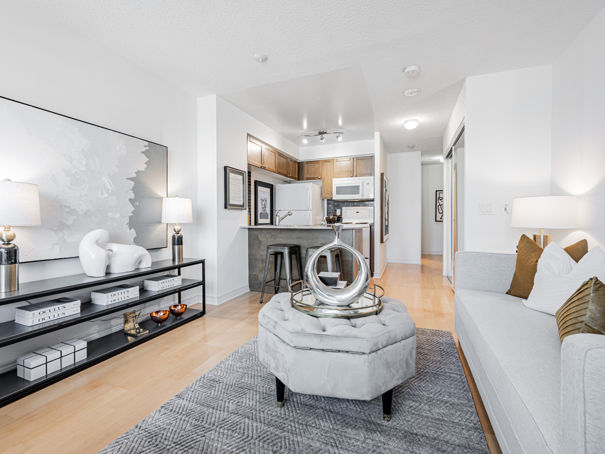 Condo living room and hallway with light hardwood floors.