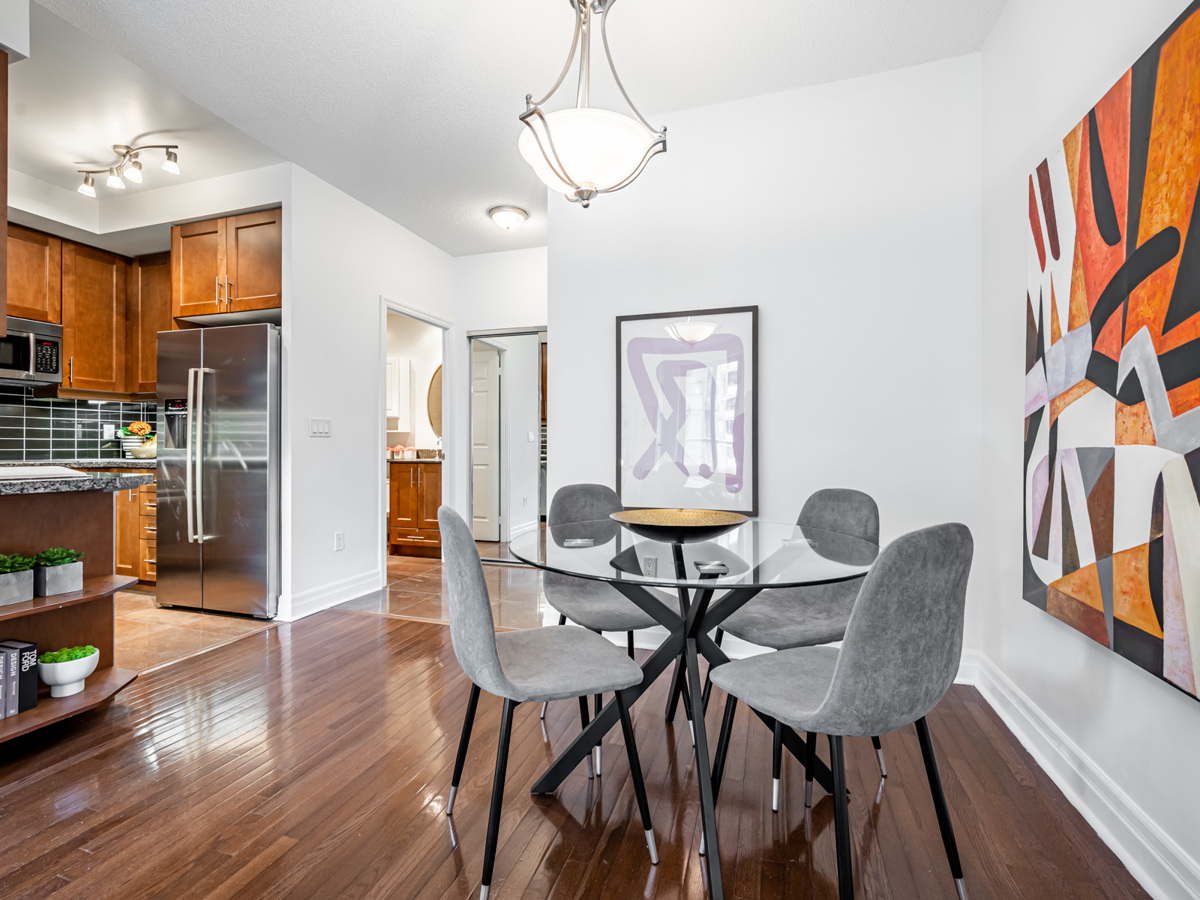 Condo dining room with elegant ceiling light overhanging dining table.