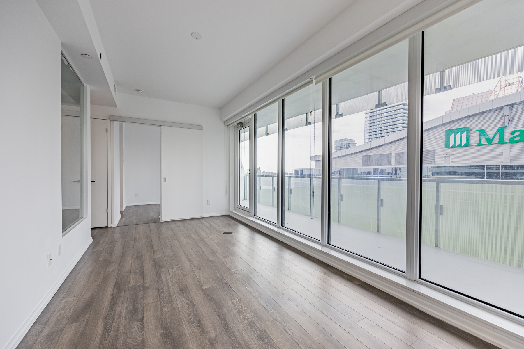 Condo living room with laminate floors and large windows.