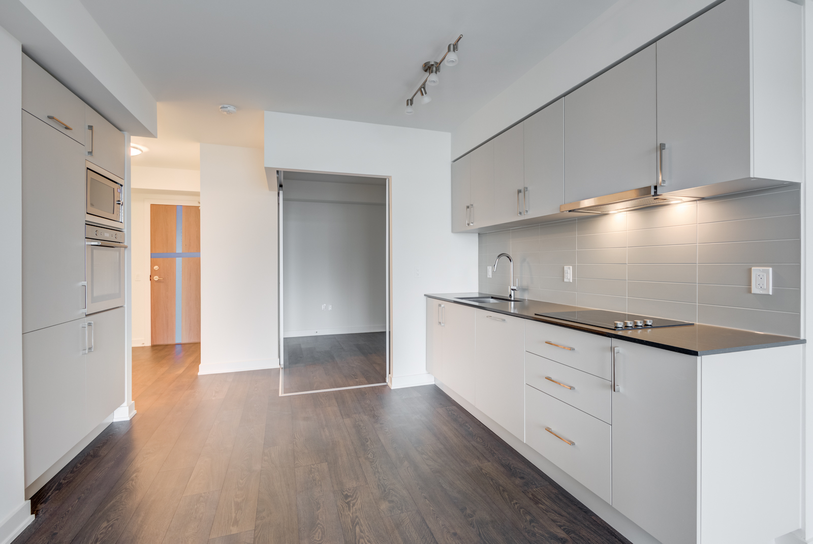 Linear gray kitchen with built-in appliances and plenty of cabinets.