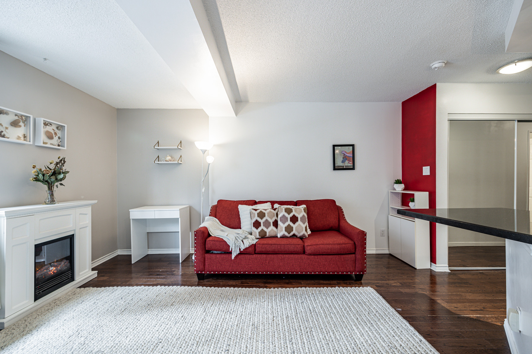 Condo with dark hardwood floors and fireplace.