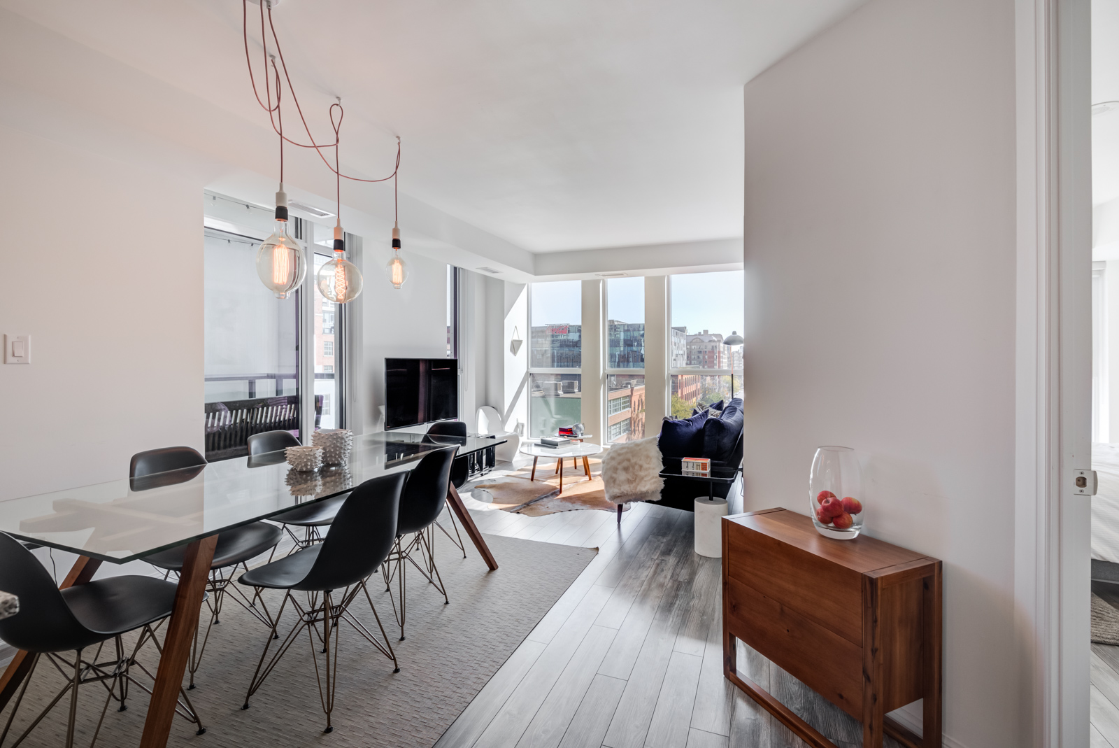 Chic pendant light-bulbs hanging above dining table of 400 Adelaide St E Unit 704 condos in Moss Park.