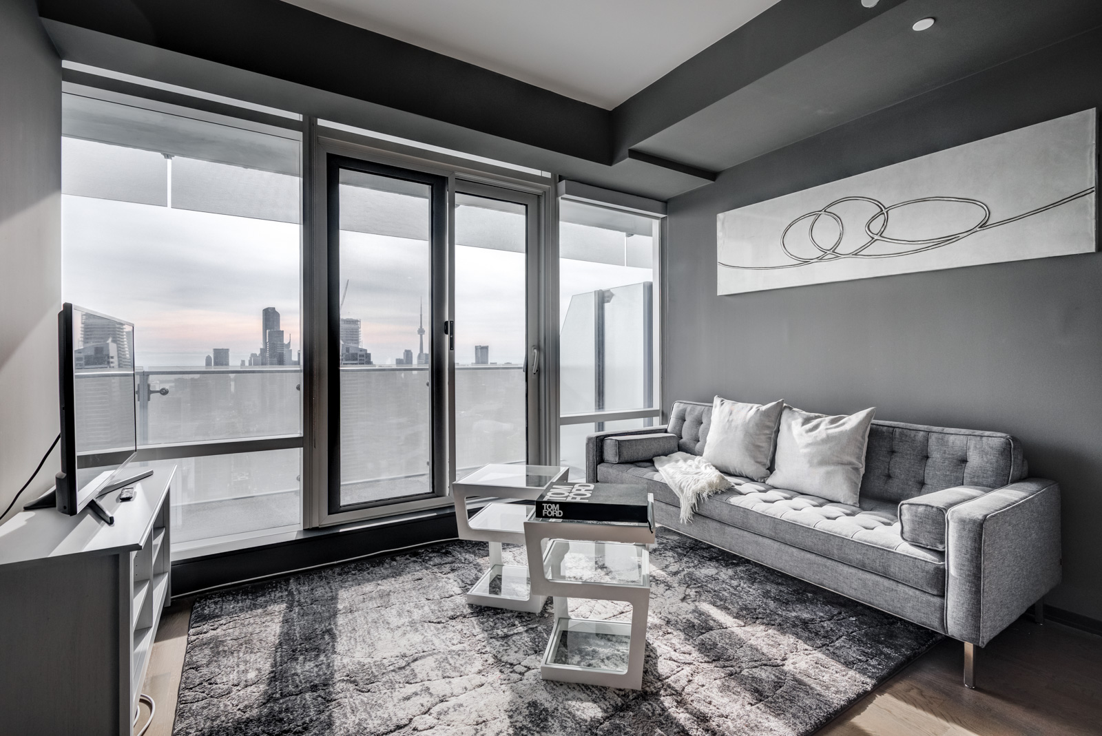 Gray-coloured living room walls, ceiling and carpet with view of CN Tower windows of 1 Bloor St E Unit 4305.