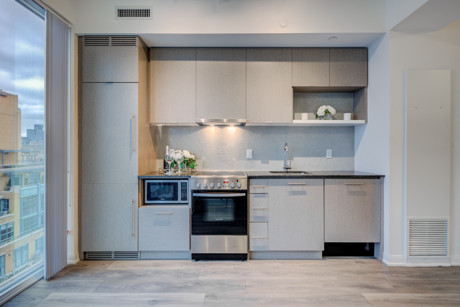 Linear kitchen with stainless-steel stove, cooktop and microwave.