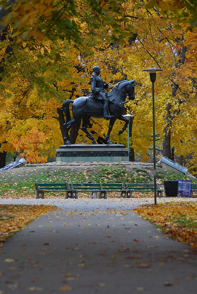 Photo of Queen's Park, trees, and statue.