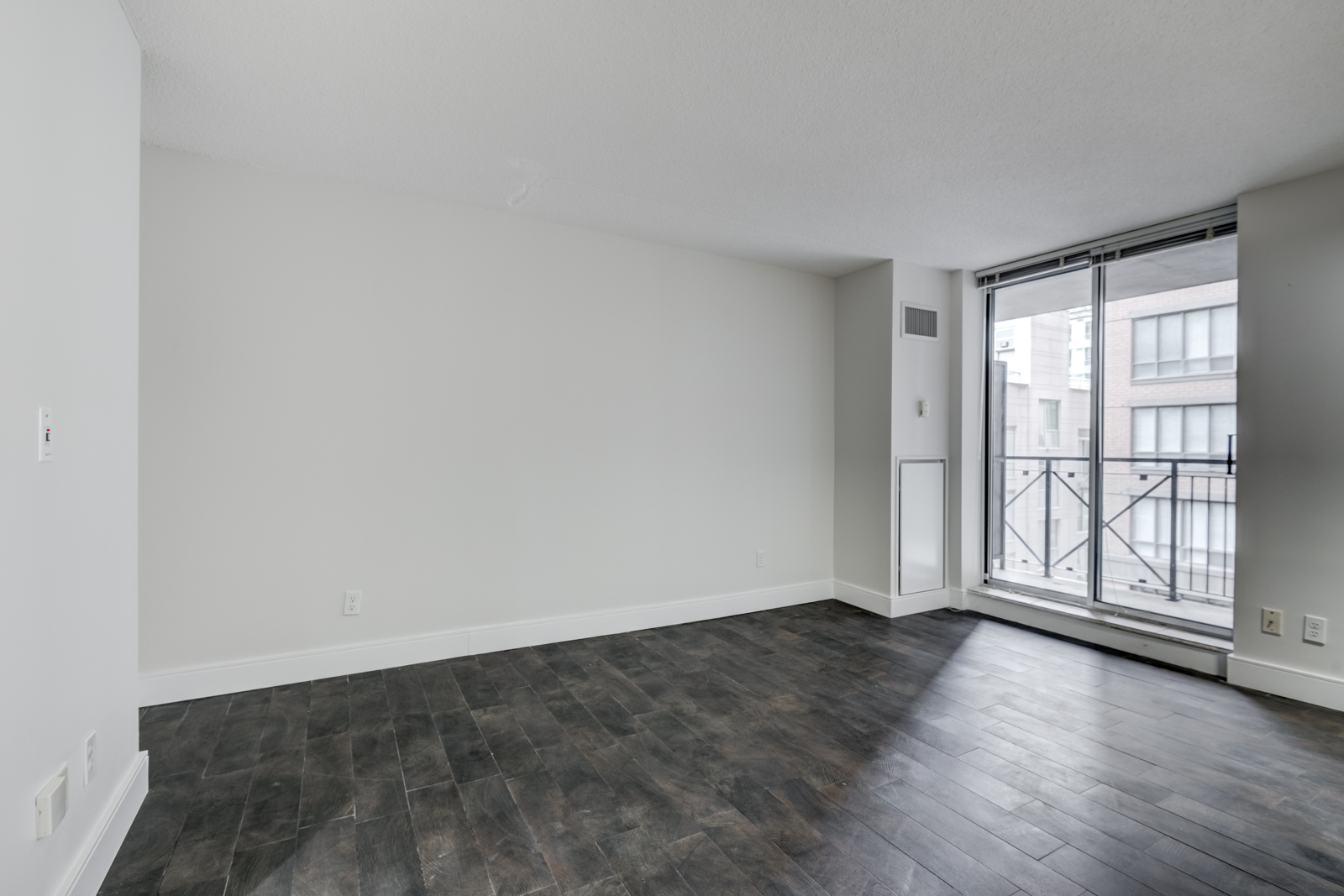 Empty condo with view of balcony and light.