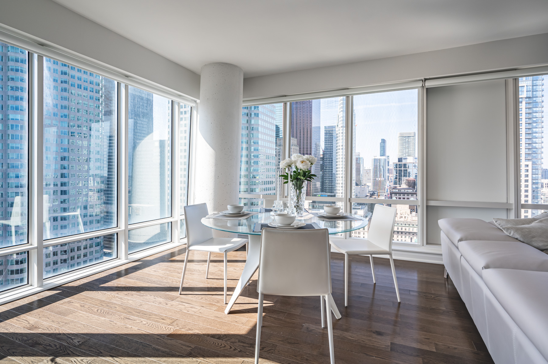 Condo dining room with view of Toronto through large windows.