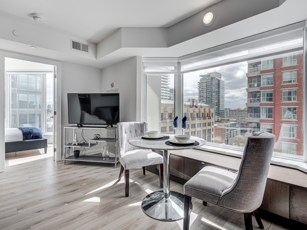 Condo dining room with bay window showing view of Yorkville, Toronto.