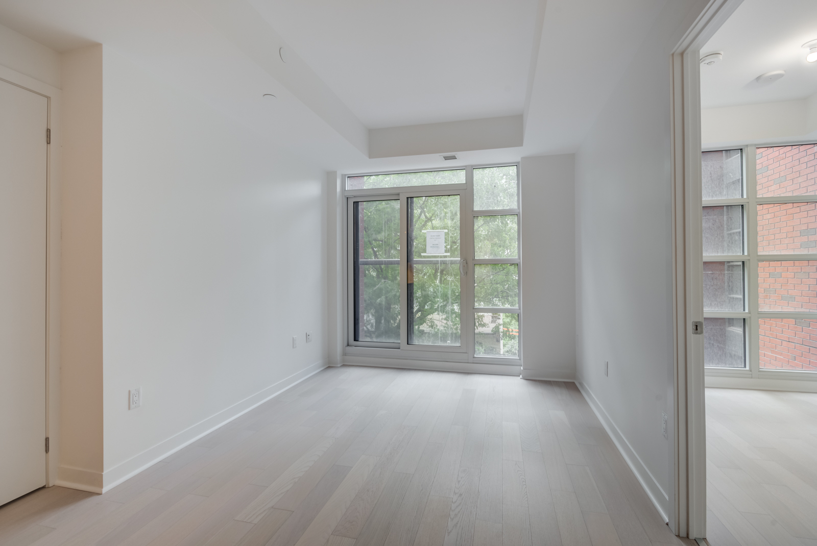 Wide view of empty living room, dining room and kitchen.