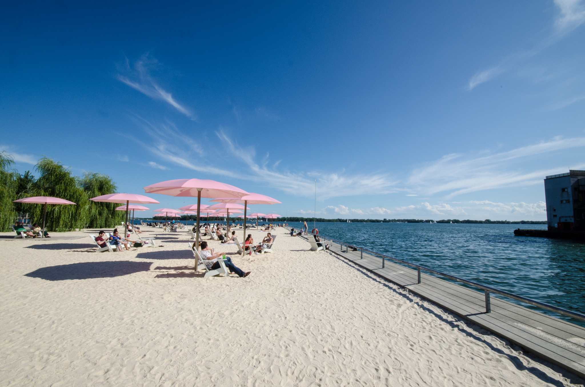 Photo of Sugar Beach in Toronto and Lakeshore. It's so bright and sunny and the water is a deep blue while the sky is a light blue.