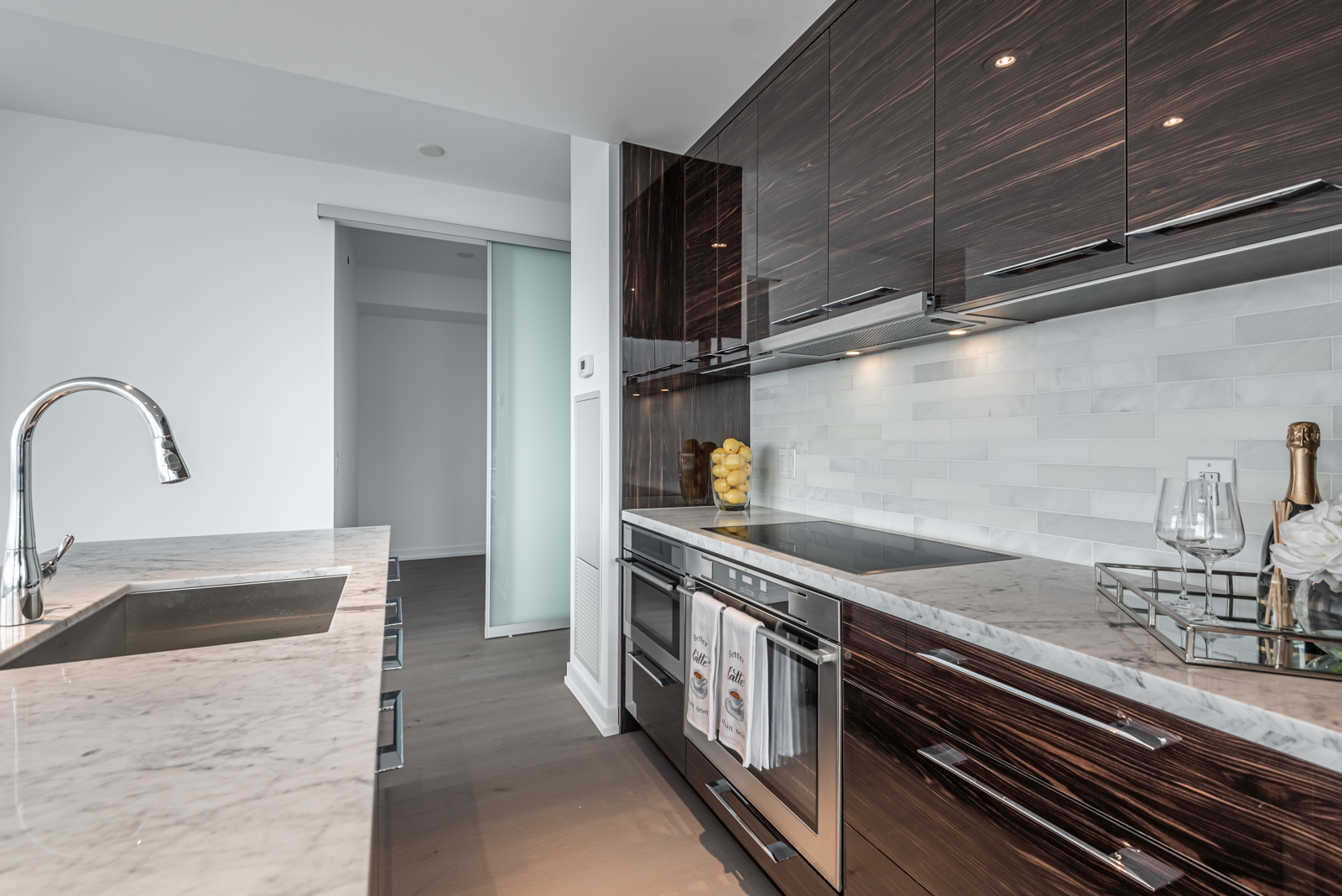 Glossy dark brown cabinets and white marble counter.