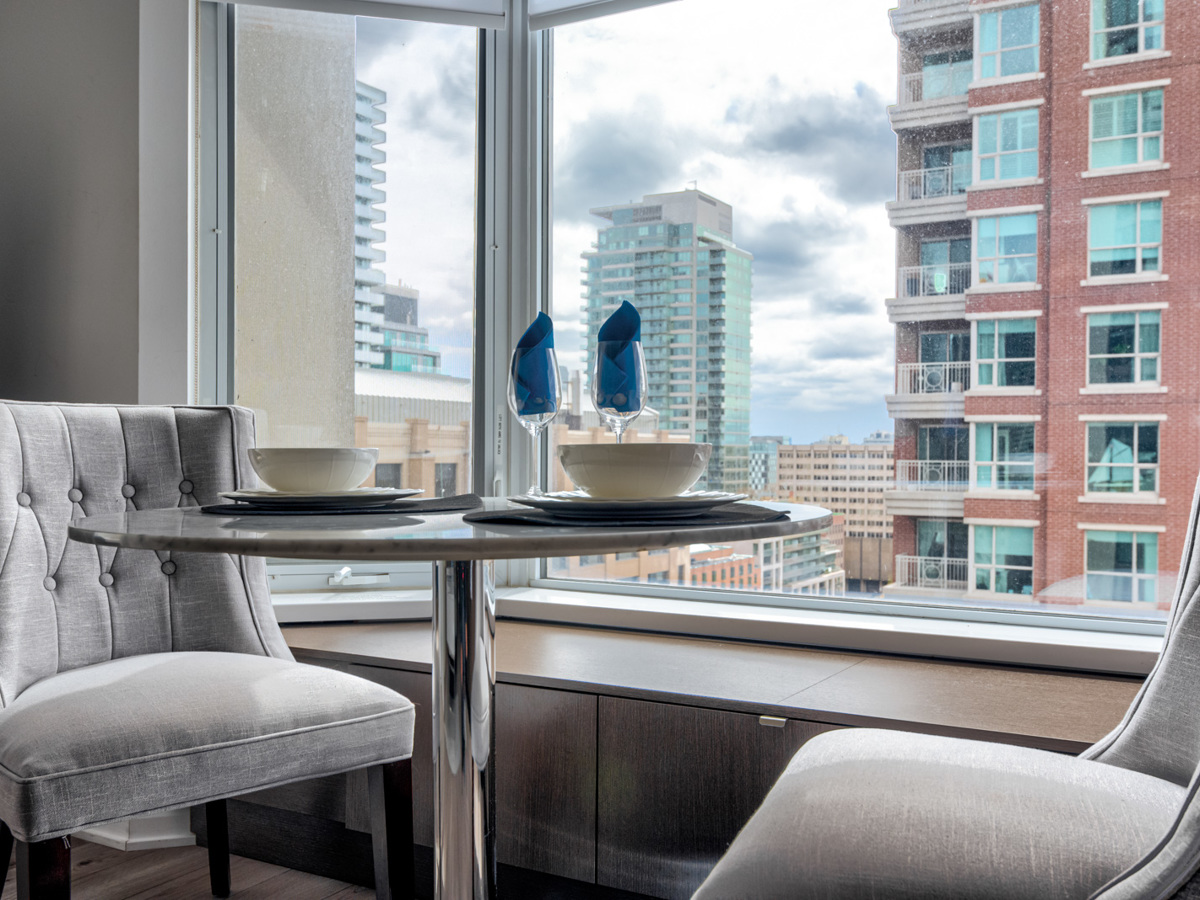 Toronto condo dining room bay window with seating and storage.