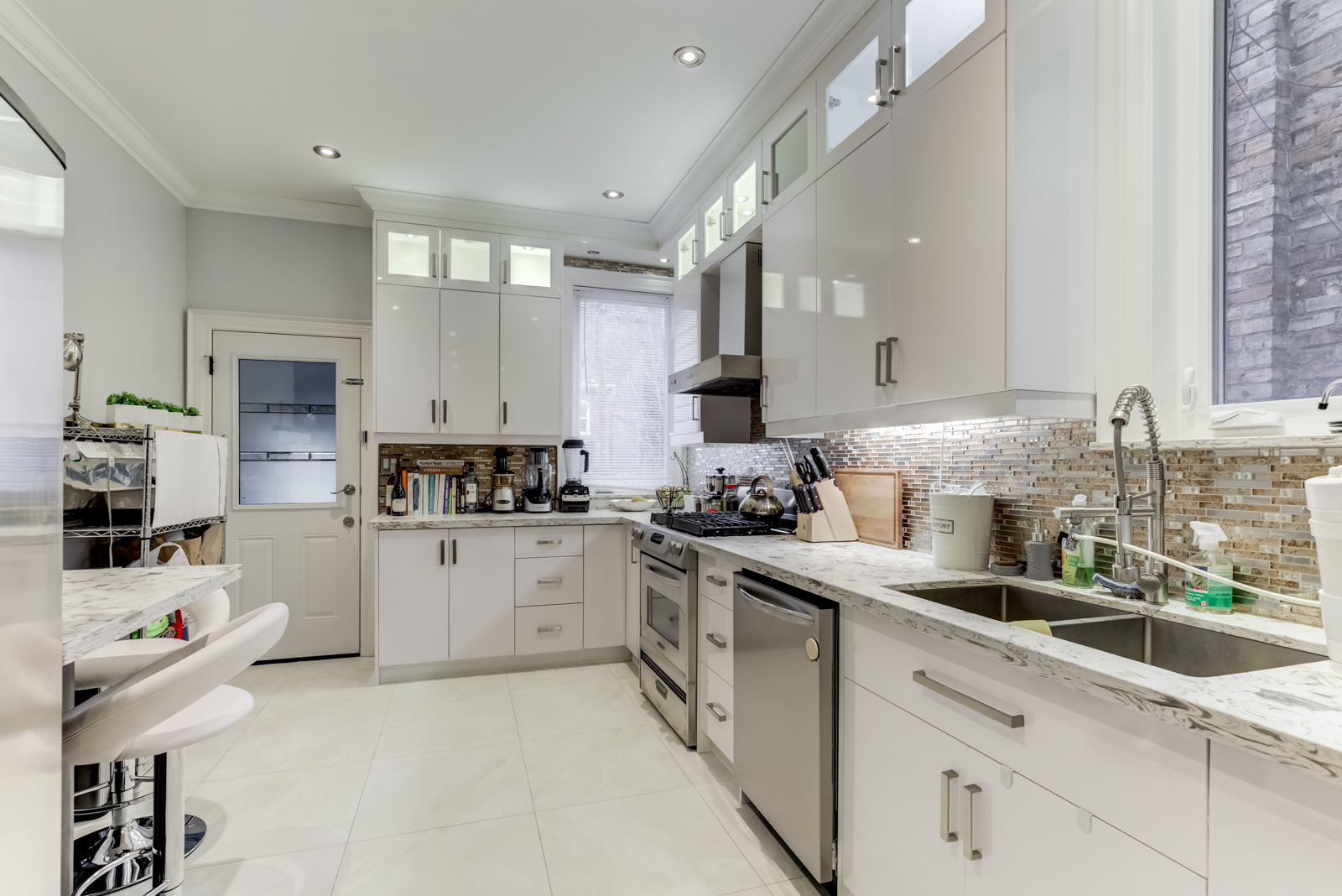 120 McGill St, renovated kitchen with silver appliances, pot-lights and gleaming white cabinets.