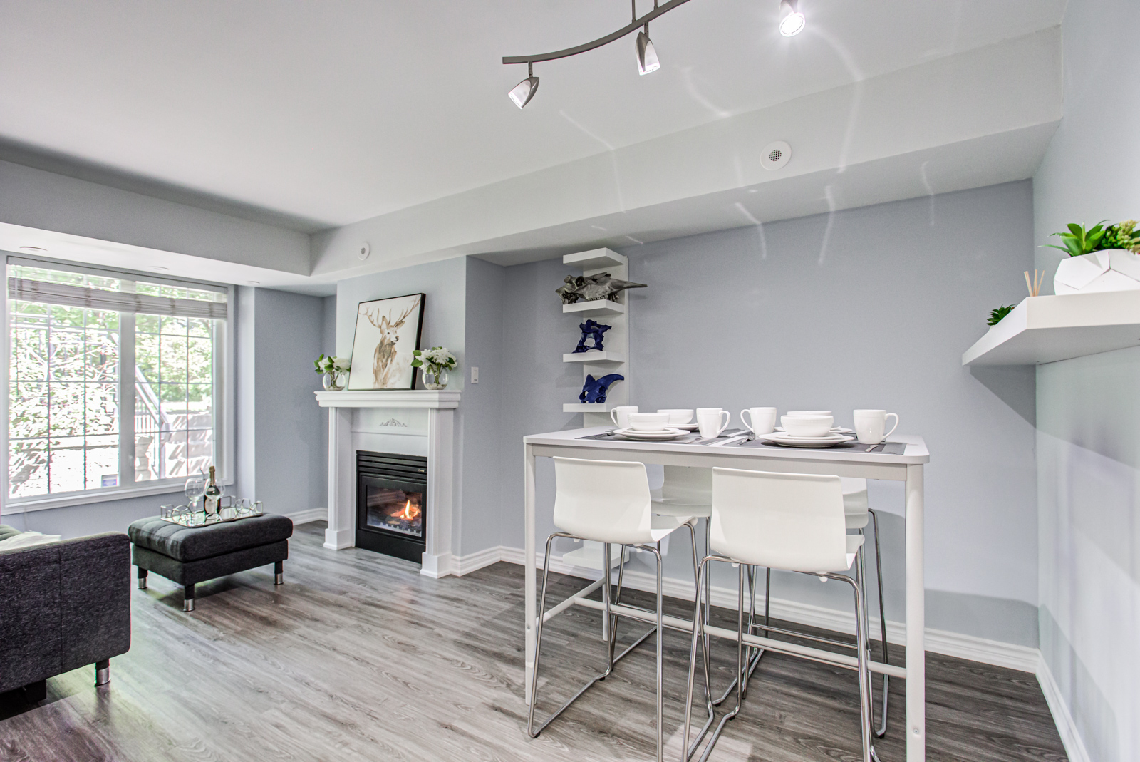 5 Everson Dr dining room with tall dining table, 4 white chairs and view of fireplace.