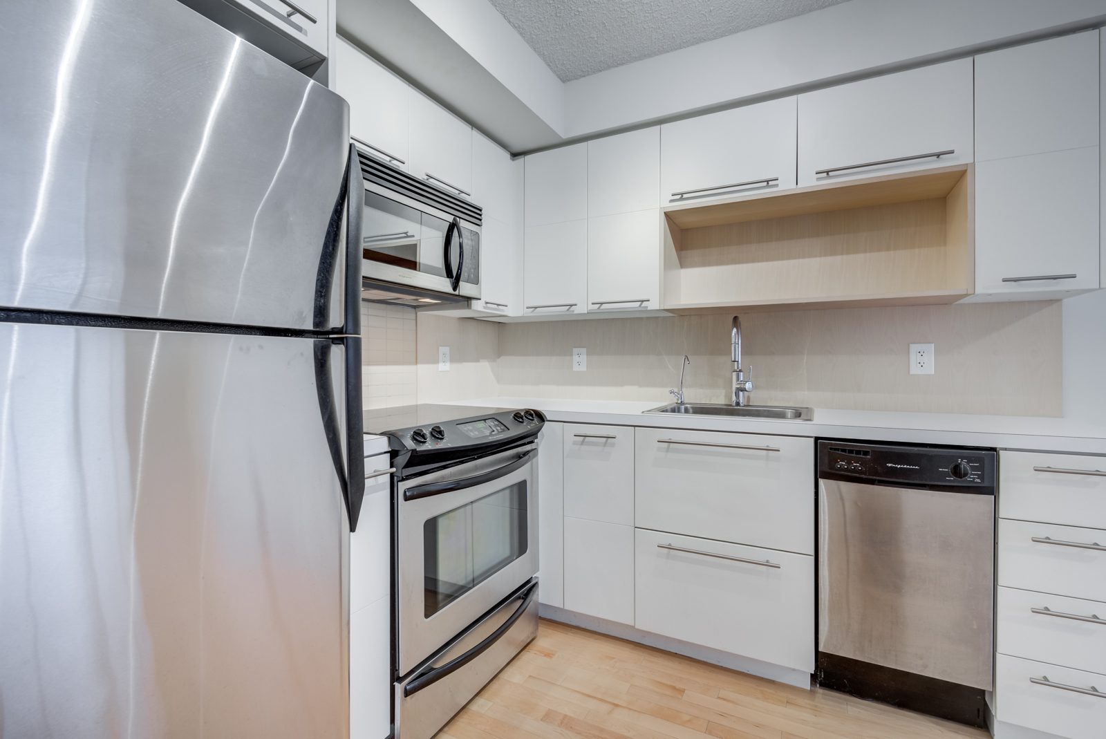 Close up view of 25 Carlton St Unit 401 kitchen cabinets and appliances.