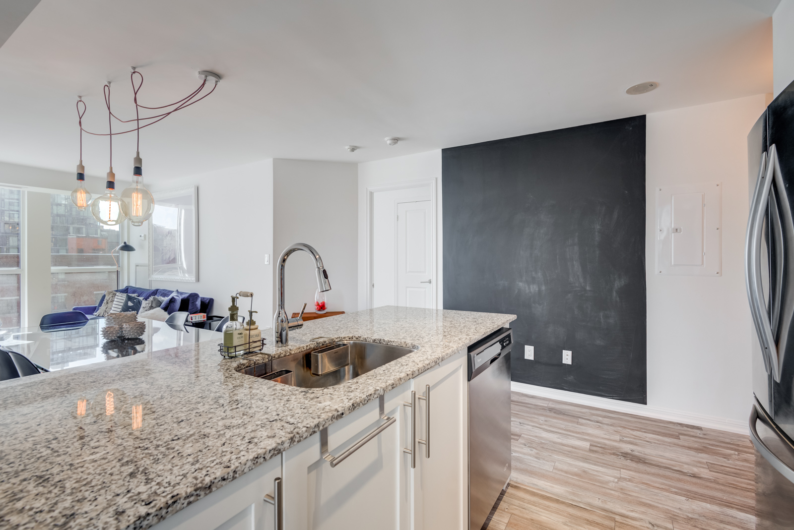 Granite counter-top, chrome faucet and blackboard wall of kitchen at 400 Adelaide St E Unit 704 condos in Moss Park.