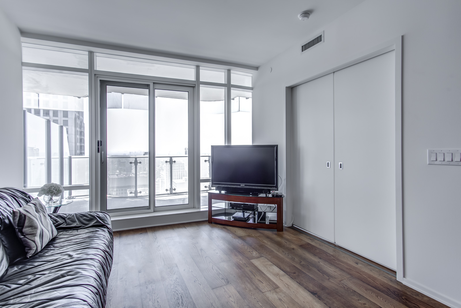 Photo of 1 Bloor St E Unit 3408 living room and balcony with huge windows.