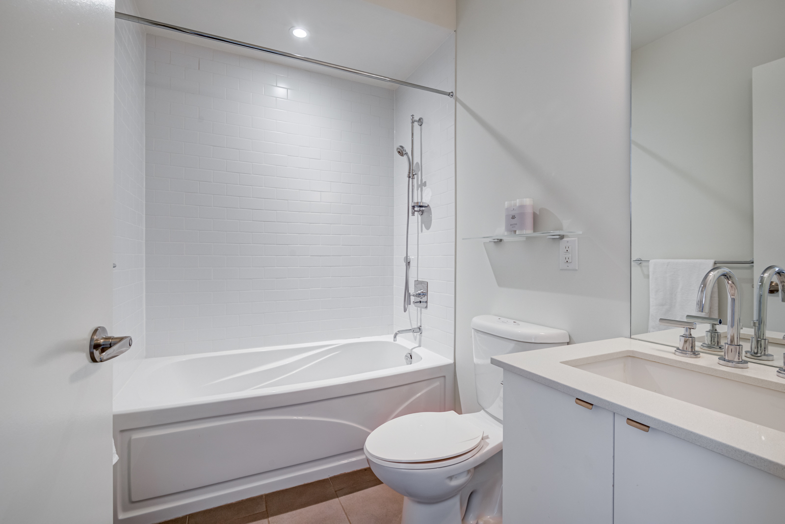 Bathroom with white tiles, tub, shelves and vanity