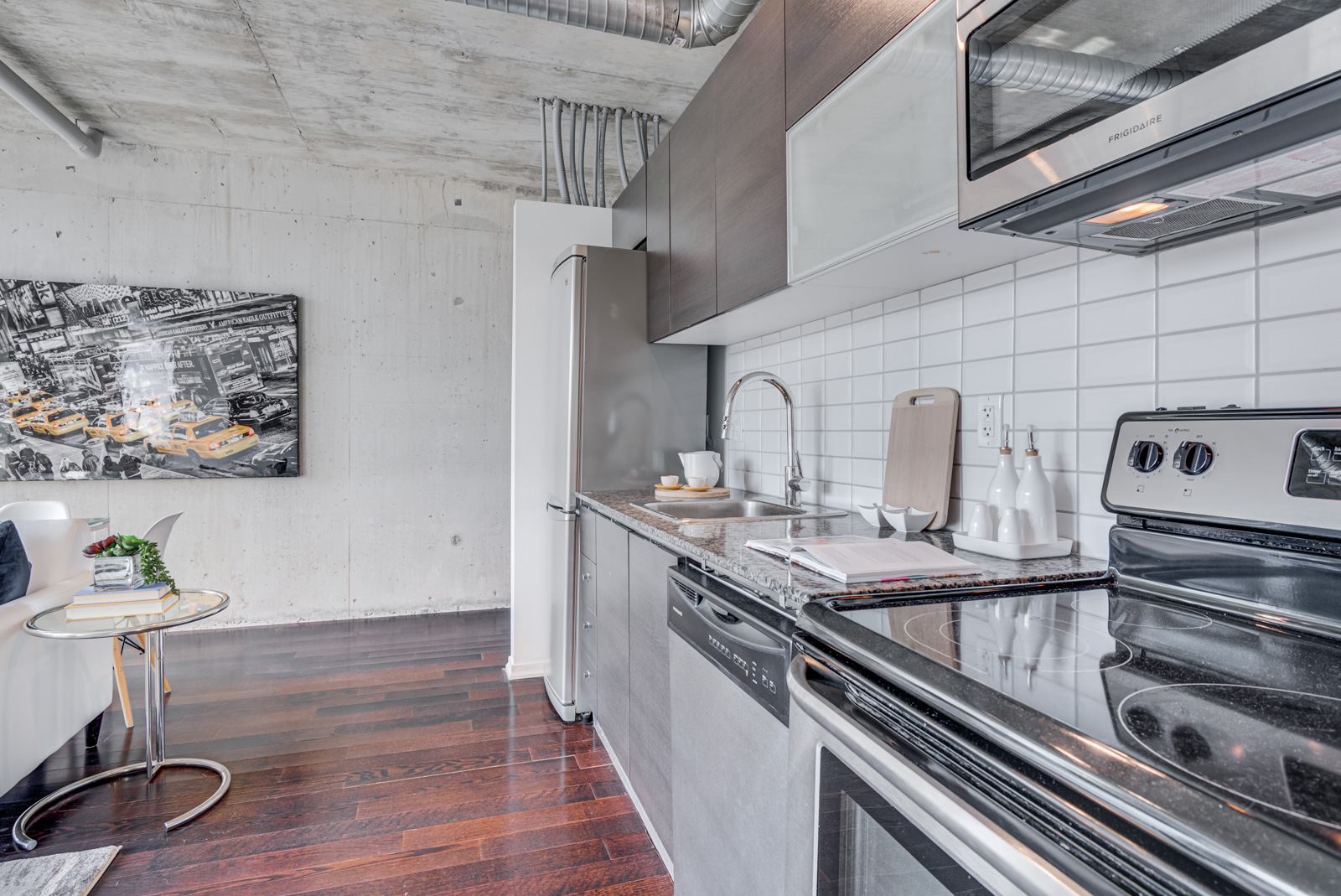 Close up of kitchen appliances, including stove, fridge and microwave.