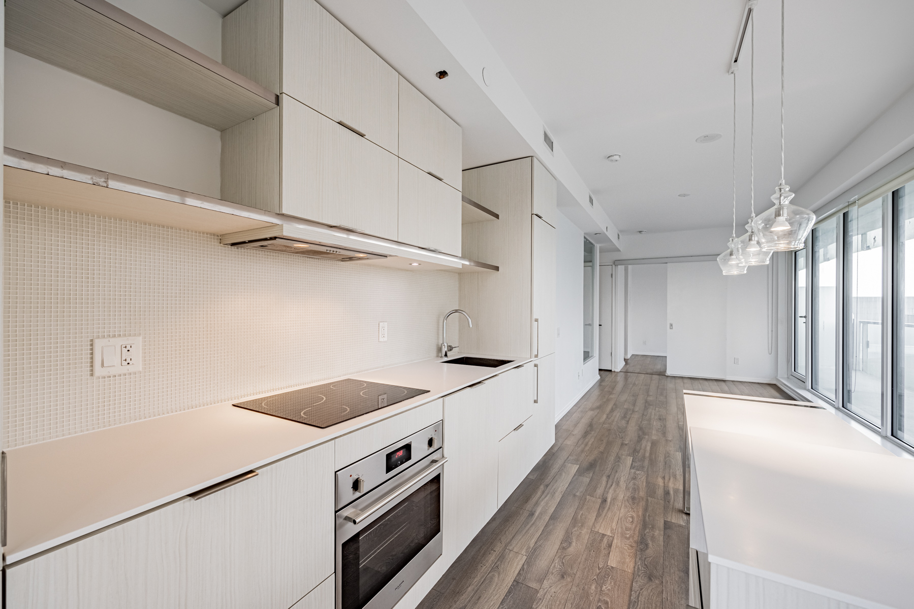 Condo kitchen with multiple cabinets and under-cabinet lighting.