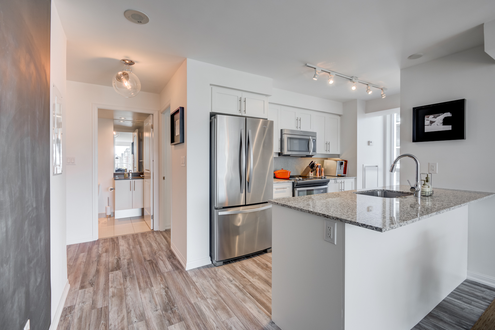 Breakfast bar with granite counter-top and stainless-steel kitchen appliances at 400 Adelaide St E Unit 704 condos in Moss Park.