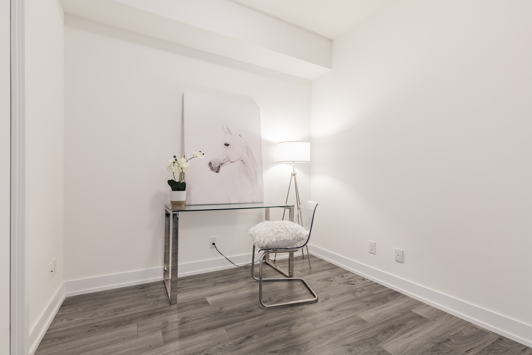 Condo den with desk, chair and horse painting.