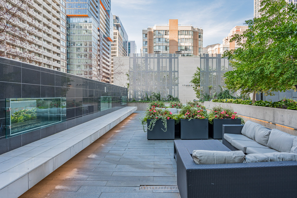 Aura Condos 5th floor deck with gas fireplace and view of buildings.