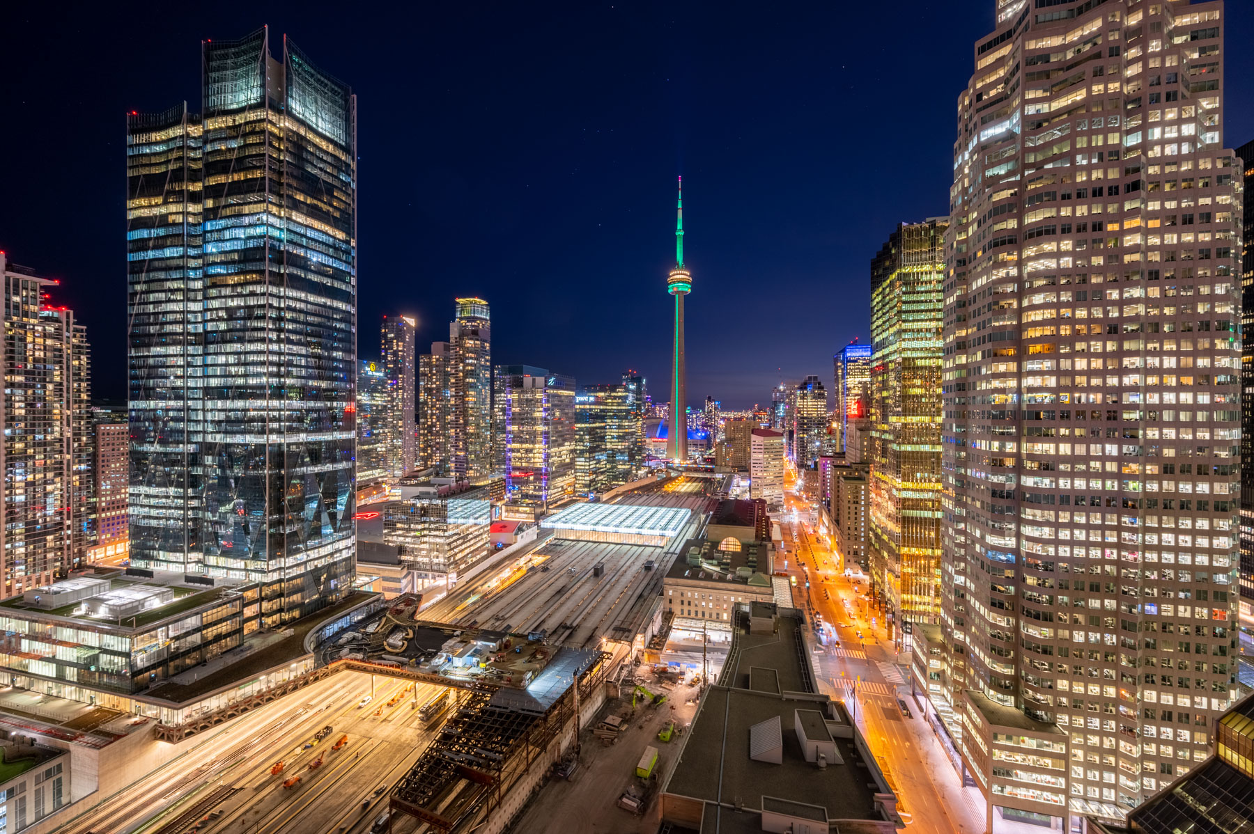 Brightly lit CN Tower and Toronto skyline at night.
