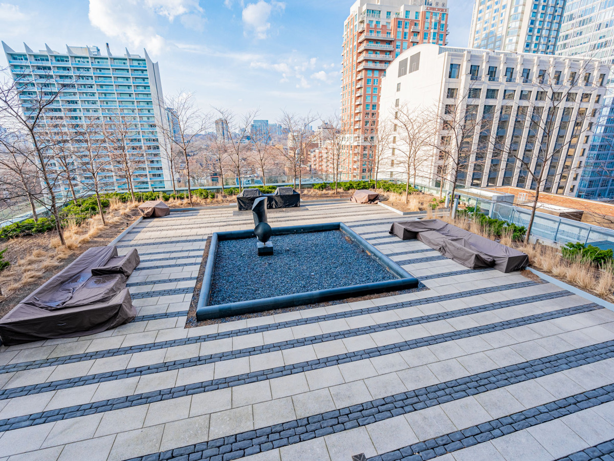 Exhibit Residences outdoor courtyard with water feature, BBQ equipment and seating.