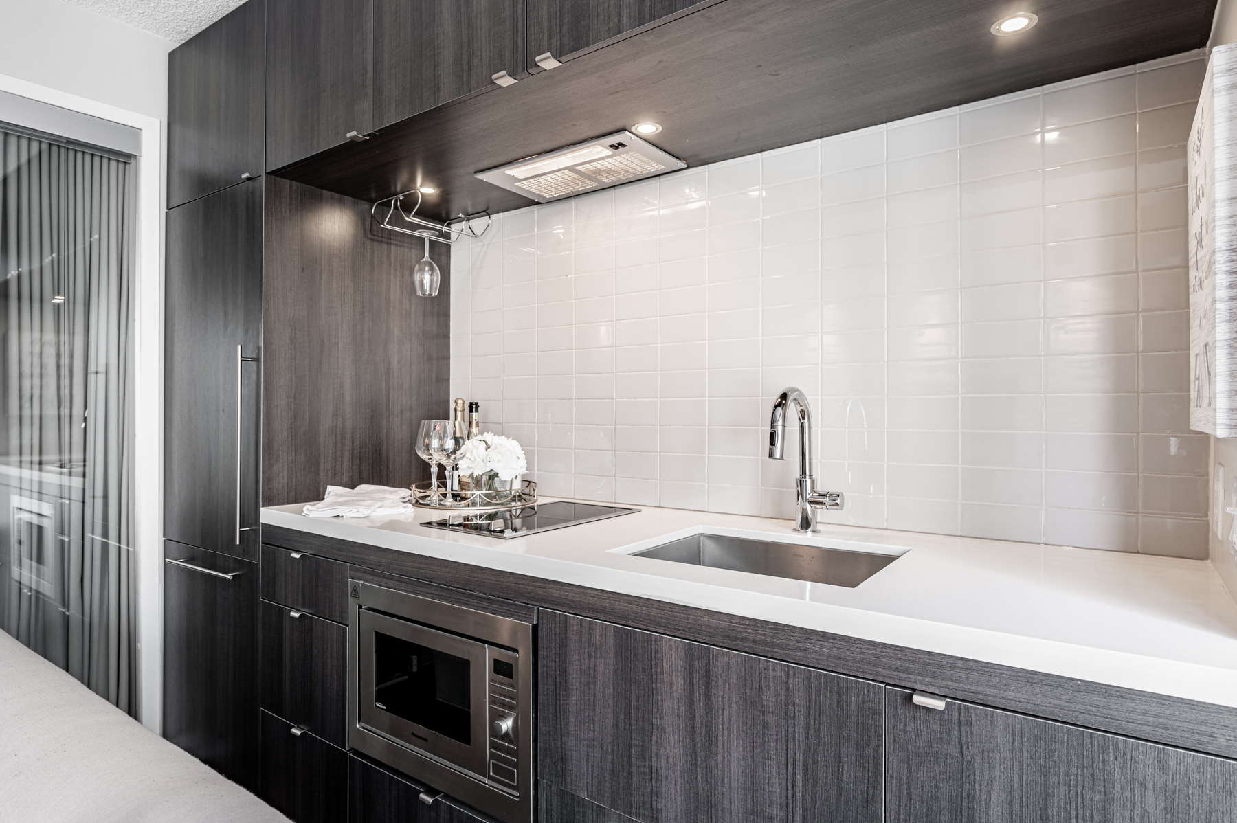 Kitchen with recessed lighting and wine glass rack.