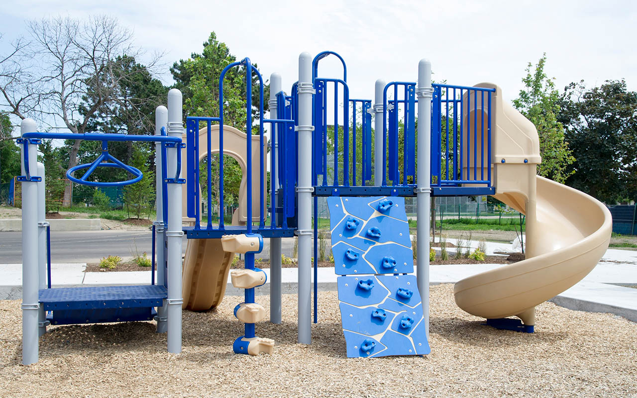Playground with bright and dark blue slides and bars at Parkway Forest Park, North York.