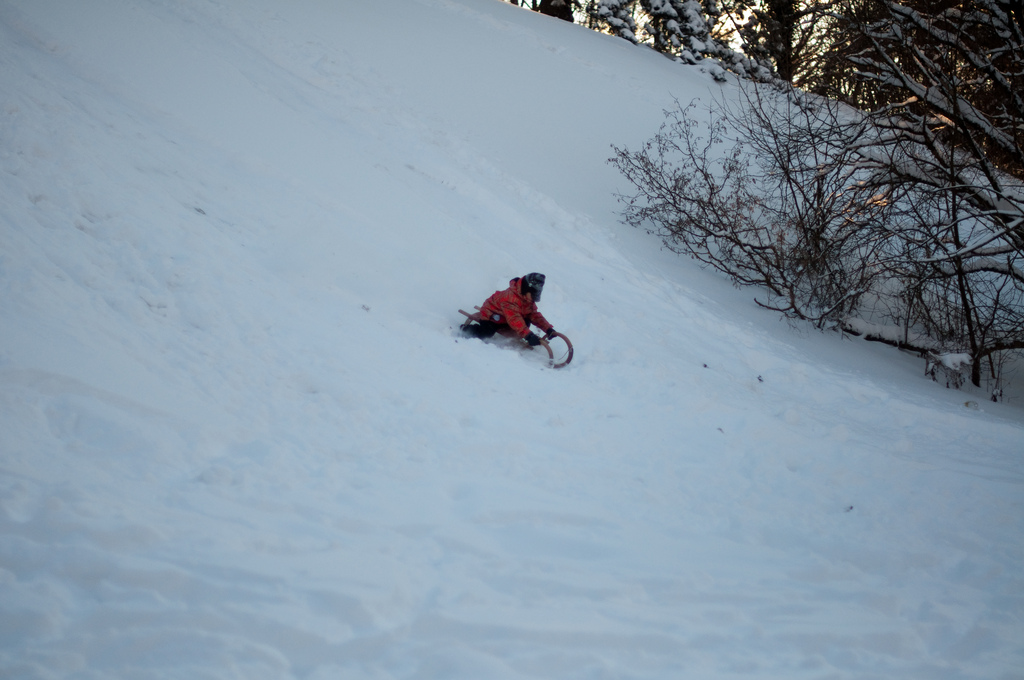 Kid tobogganing down a hill