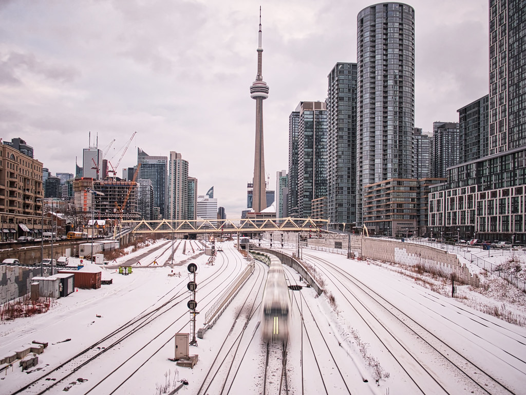 View of Toronto's CN Tower and train tracks in December winter season.