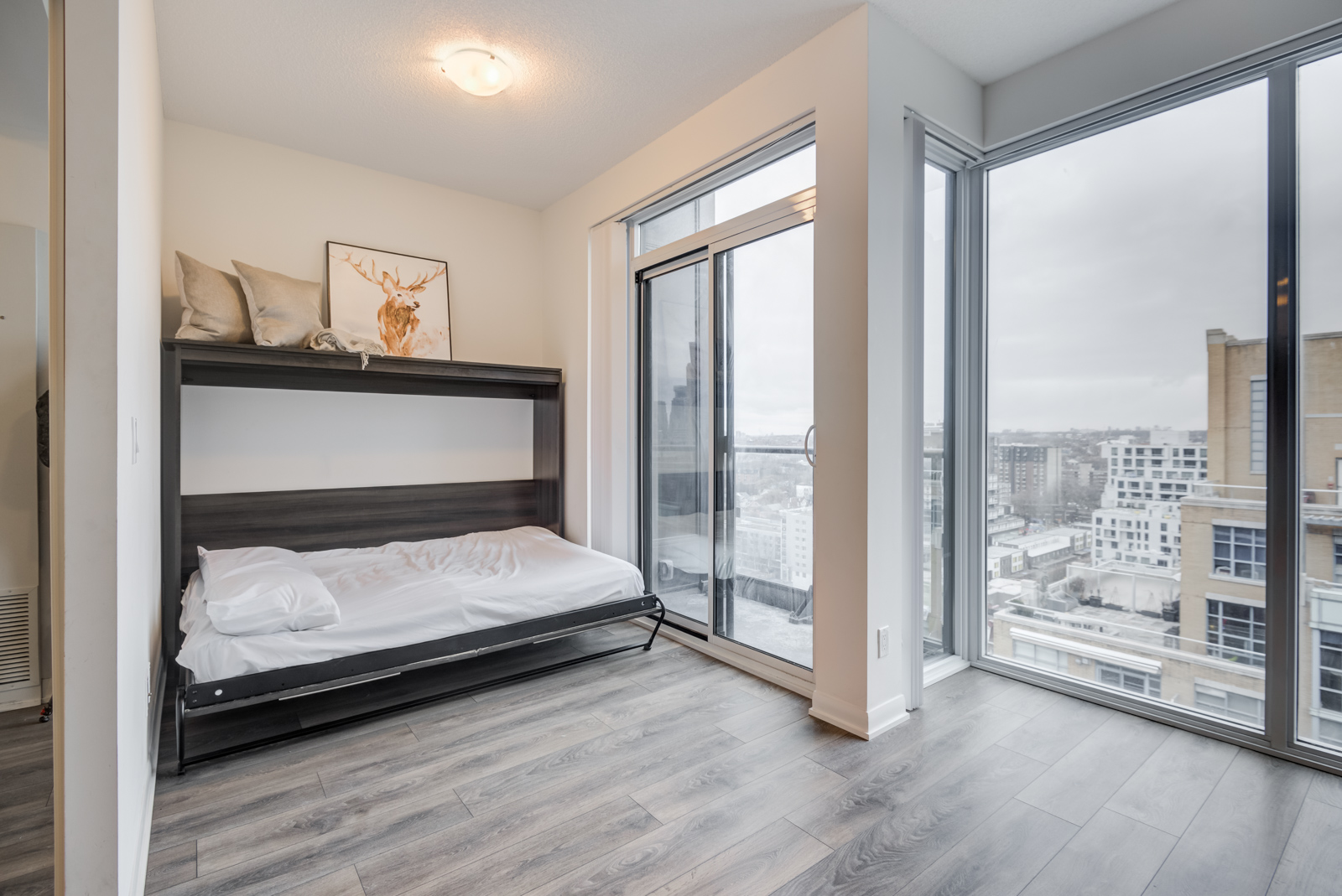 The penthouse suite with an open Murphy bed with white covers and pillow.