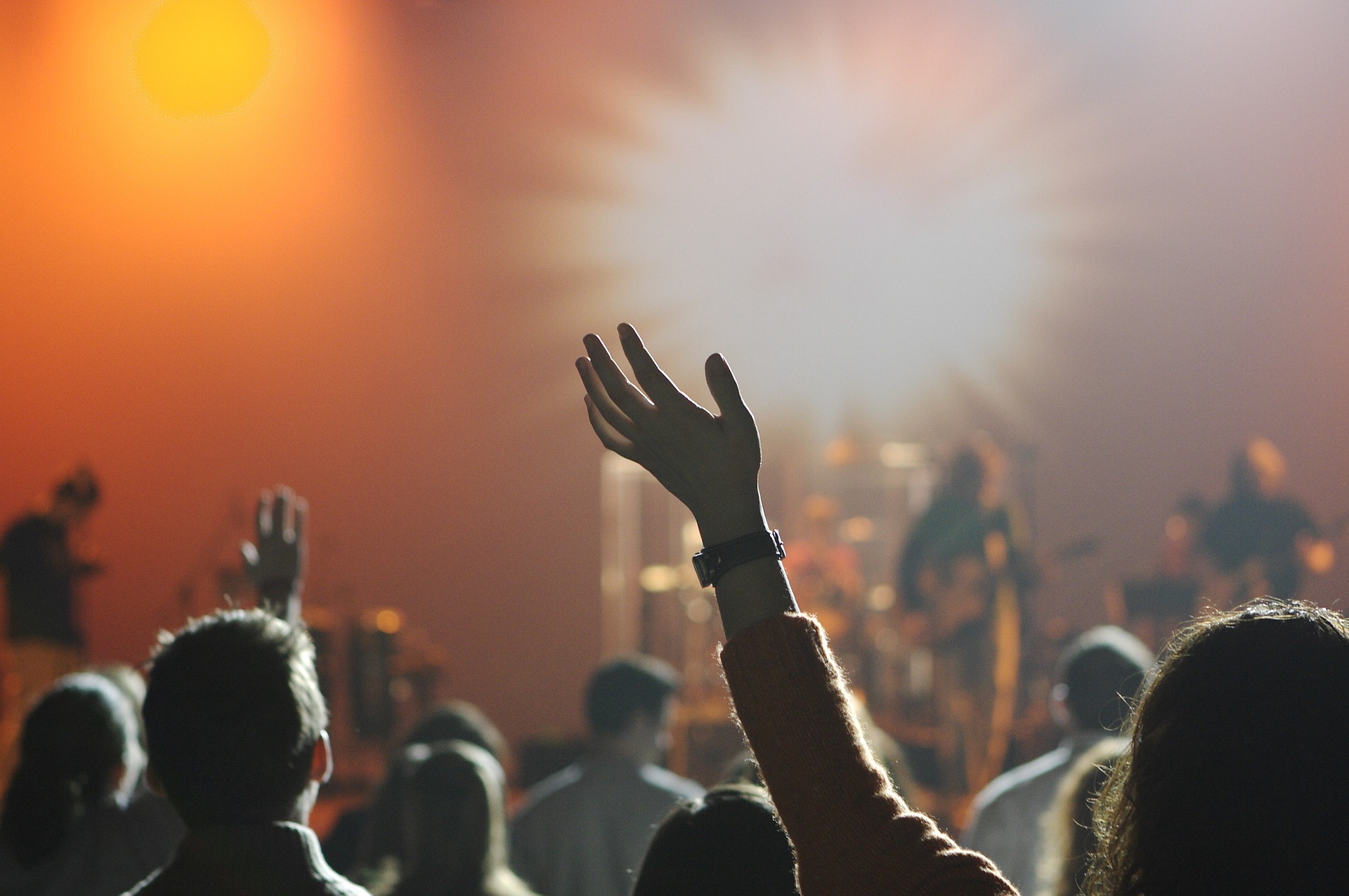 Pic of concert and people with arms in the air.